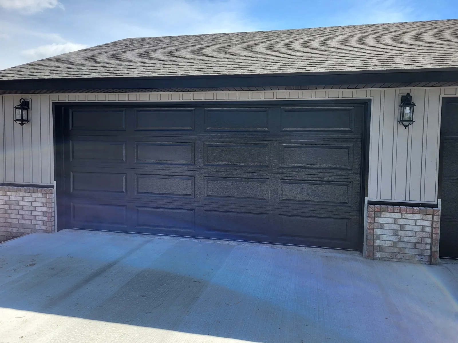 Black residential garage door installed by Triple B Garage Doors