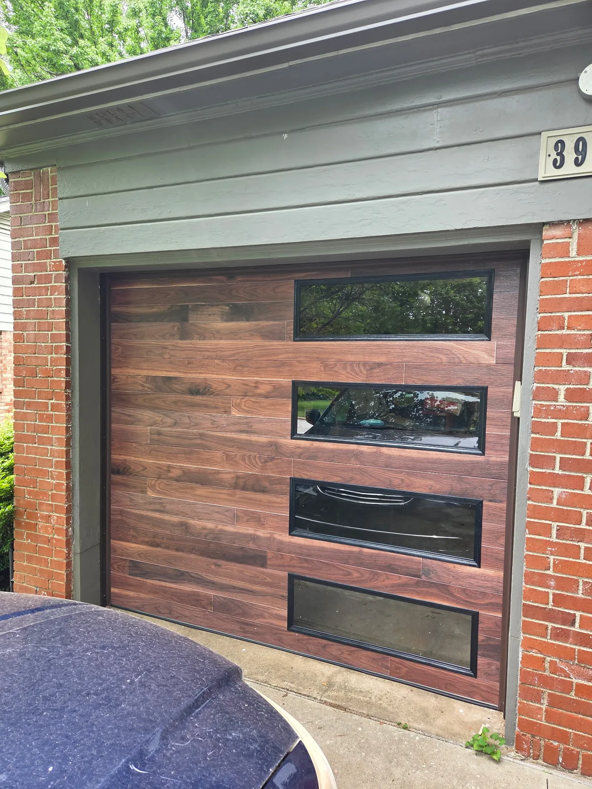 Modern wood-look garage door with horizontal glass panels